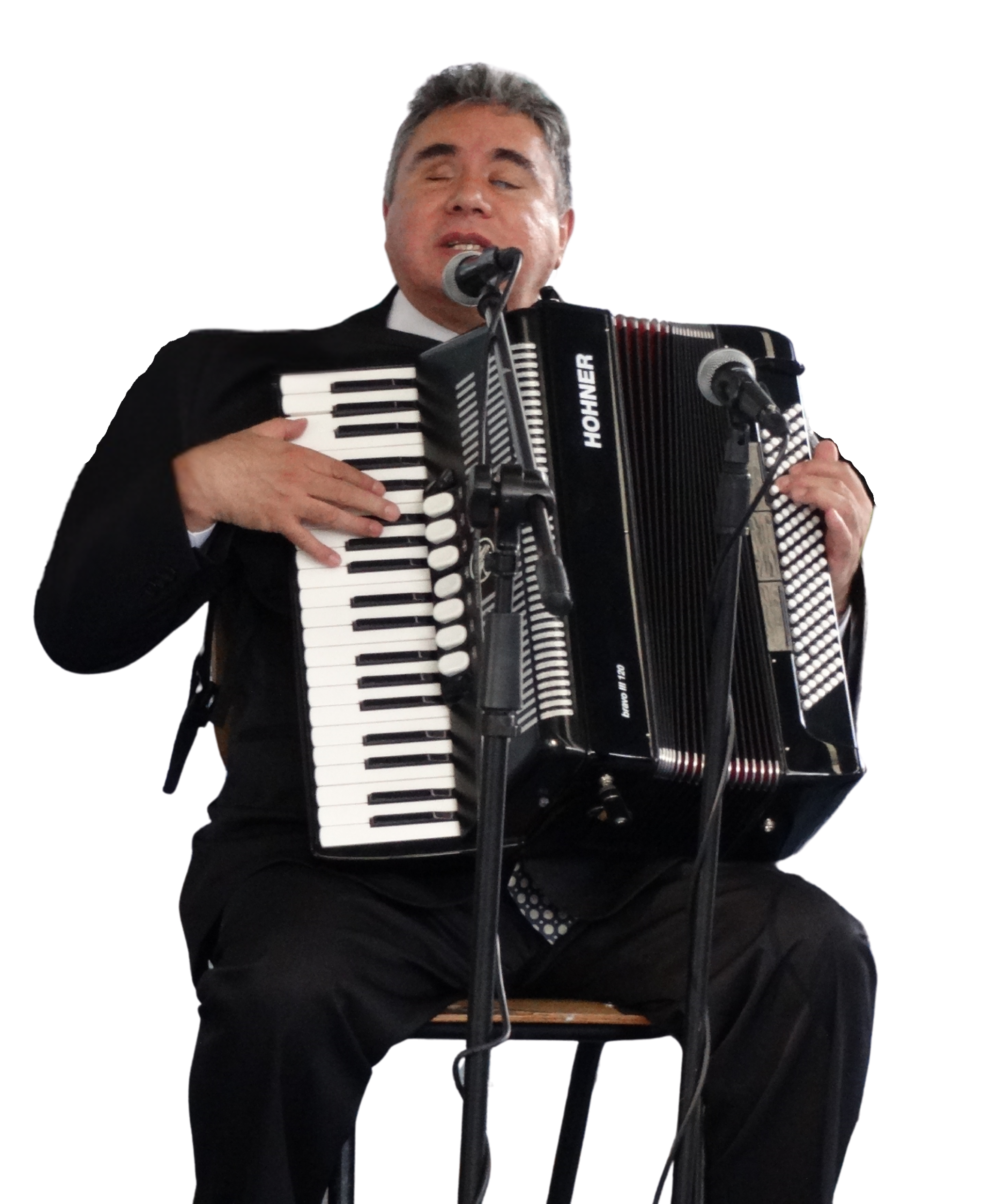 Fotografía de Eagleman tocando un acordeón en una presentación en vivo, acompañado de micrófonos para amplificación.