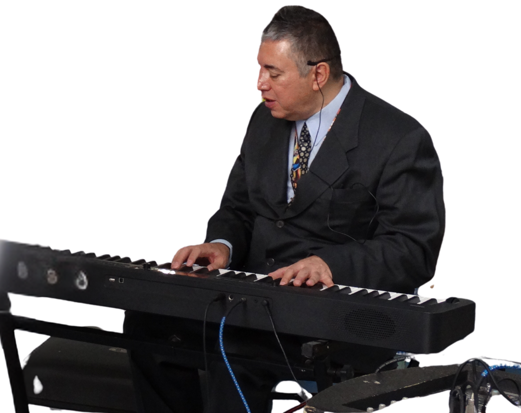 Fotografía de Eagleman vestido formalmente, tocando un teclado electrónico en una presentación en vivo.